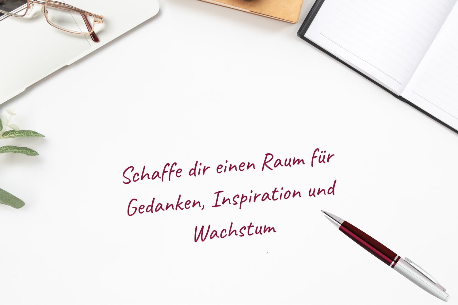 Heller Schreibtisch mit Laptop, Brille, offenem Notizbuch, Kugelschreiber und Eukalyptuszweig, dazu der handgeschriebene Satz „Schaffe dir einen Raum für Gedanken, Inspiration und Wachstum“