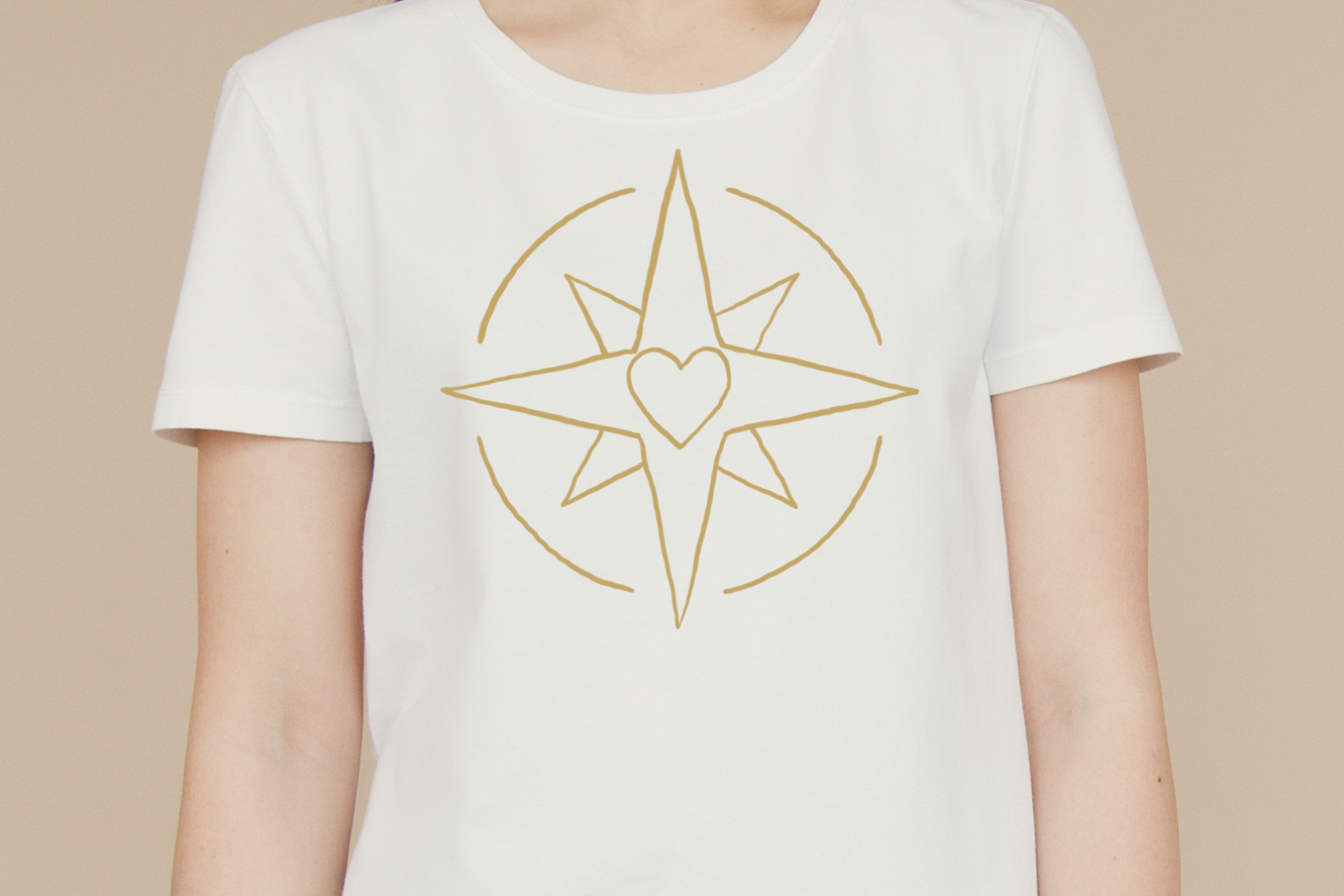 Person trägt ein T-Shirt mit der Illustration eines Kompasses mit Herz als Symbol für das Coaching „Finde dein Warum“.