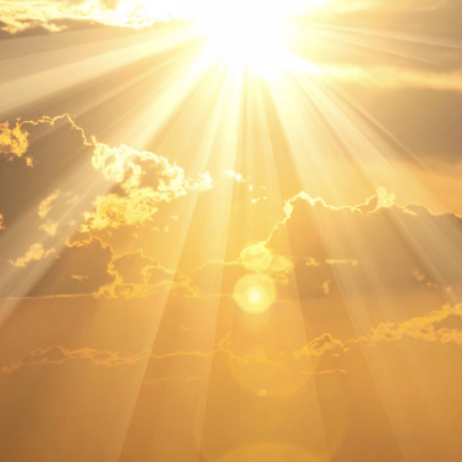 Helle Sonne, die über dunklen Wolken in einem leuchtend orangefarbenen Himmel strahlt