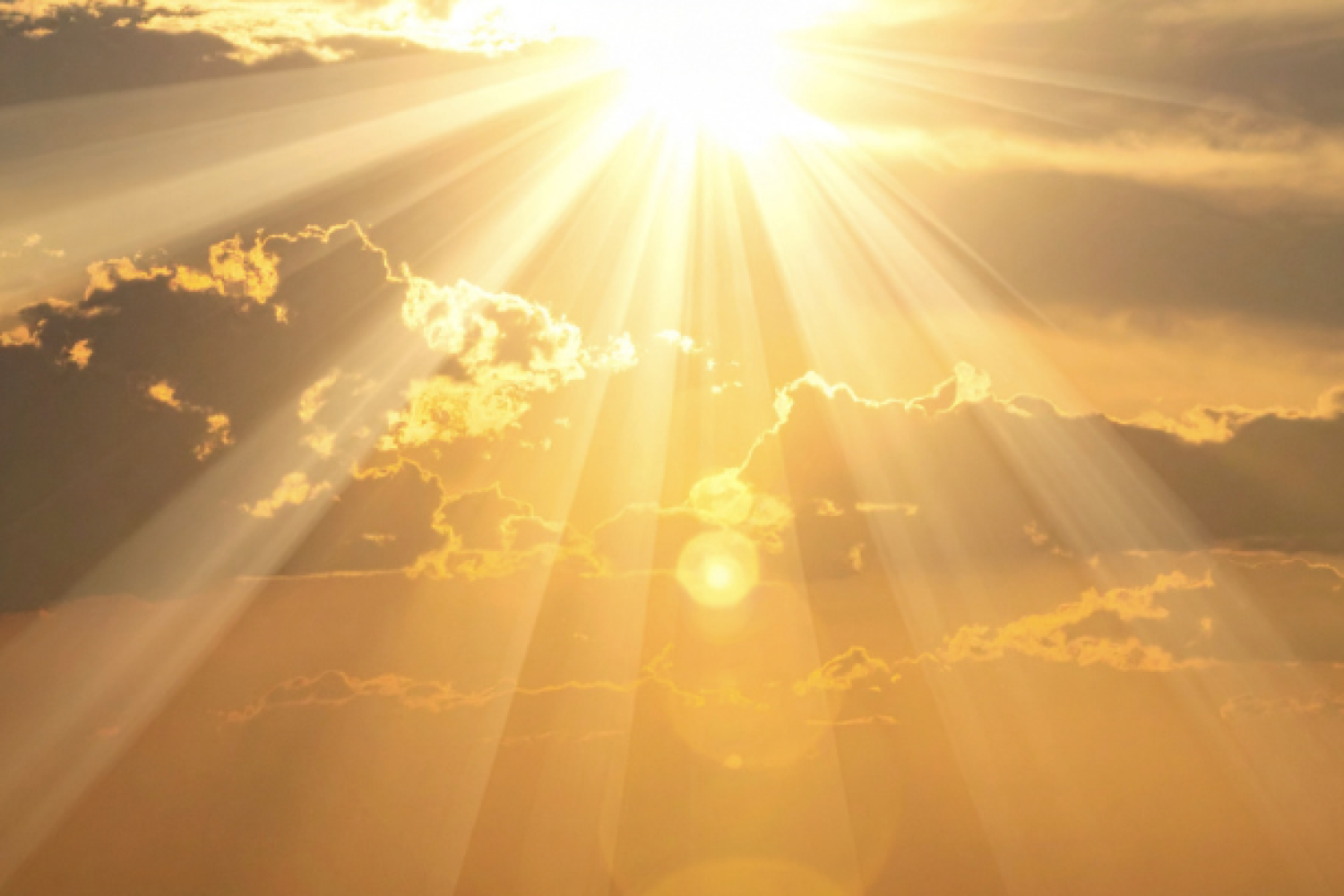 Helle Sonne, die über dunklen Wolken in einem leuchtend orangefarbenen Himmel strahlt