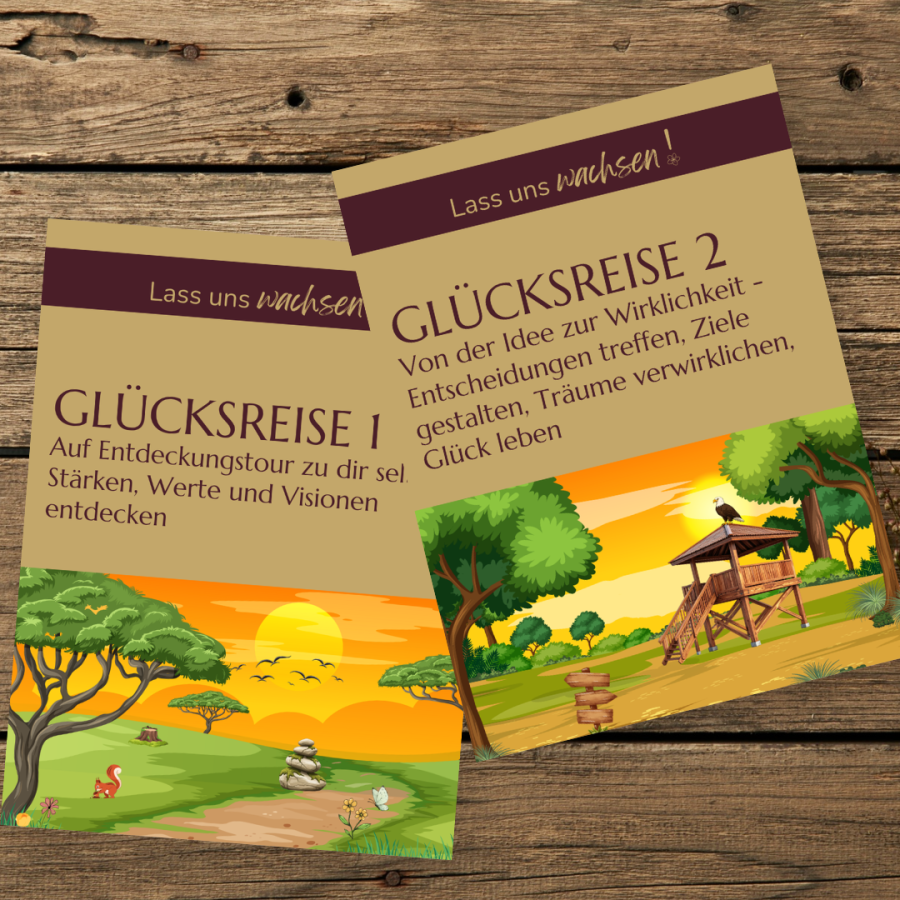 Die Cover der Workbooks „Glücksreise 1“ und „Glücksreise 2“, leicht versetzt auf einem Holztisch, daneben ein Strauß Trockenblumen