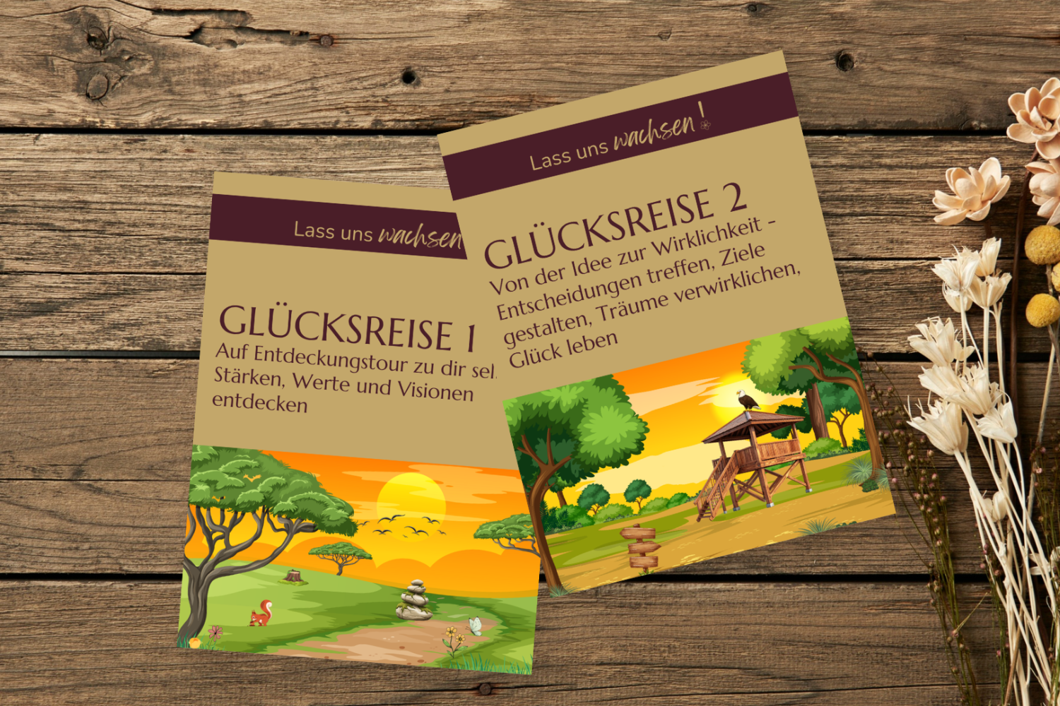 Die Cover der Workbooks „Glücksreise 1“ und „Glücksreise 2“, leicht versetzt auf einem Holztisch, daneben ein Strauß Trockenblumen